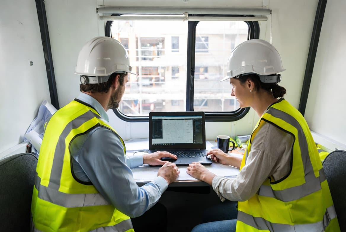 Site compliance team reviewing records on a laptop
